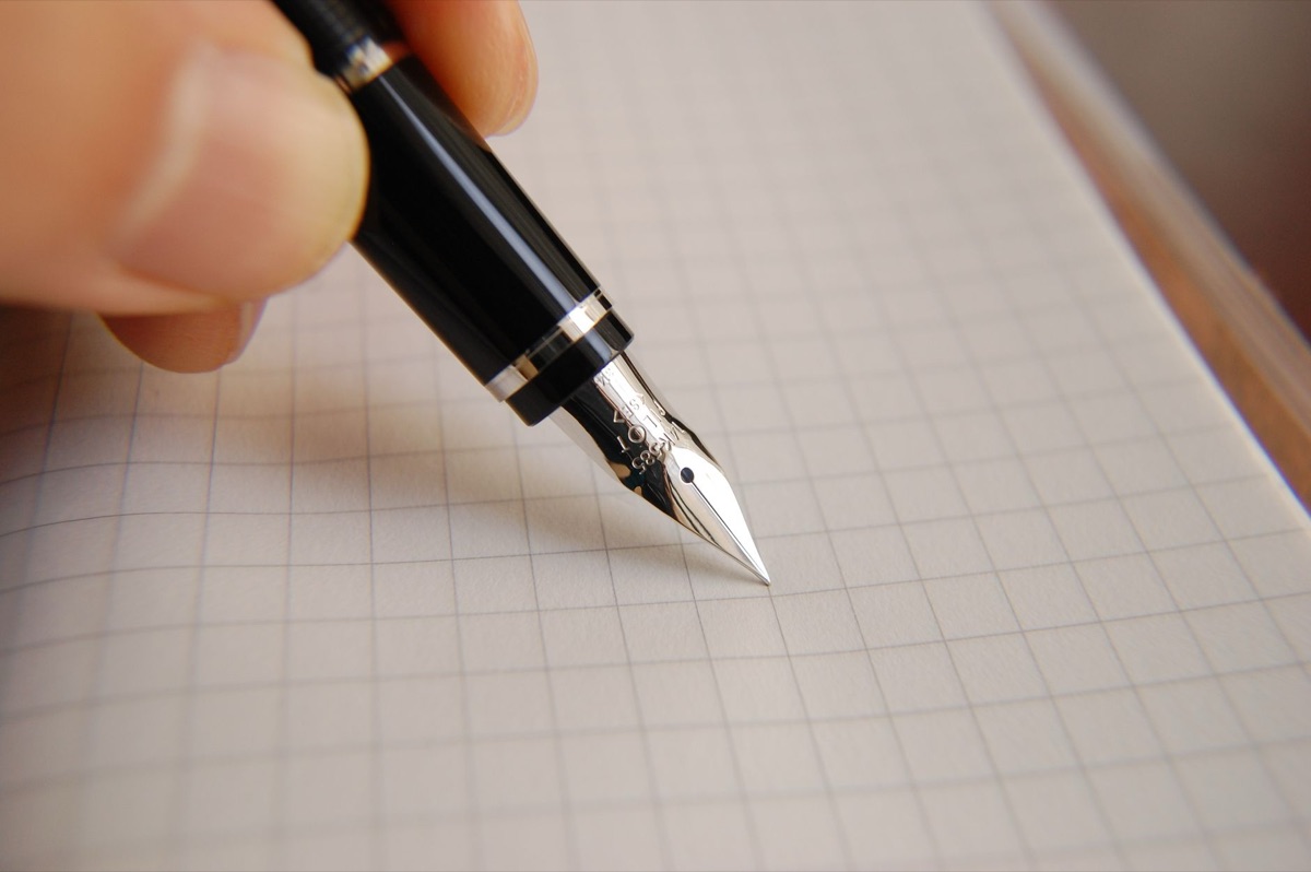 Escritura creativa para ensayos universitarios con pluma y diario.