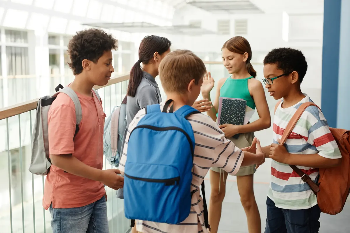 A diverse group of students interacting in a school hallway, fostering social connections.